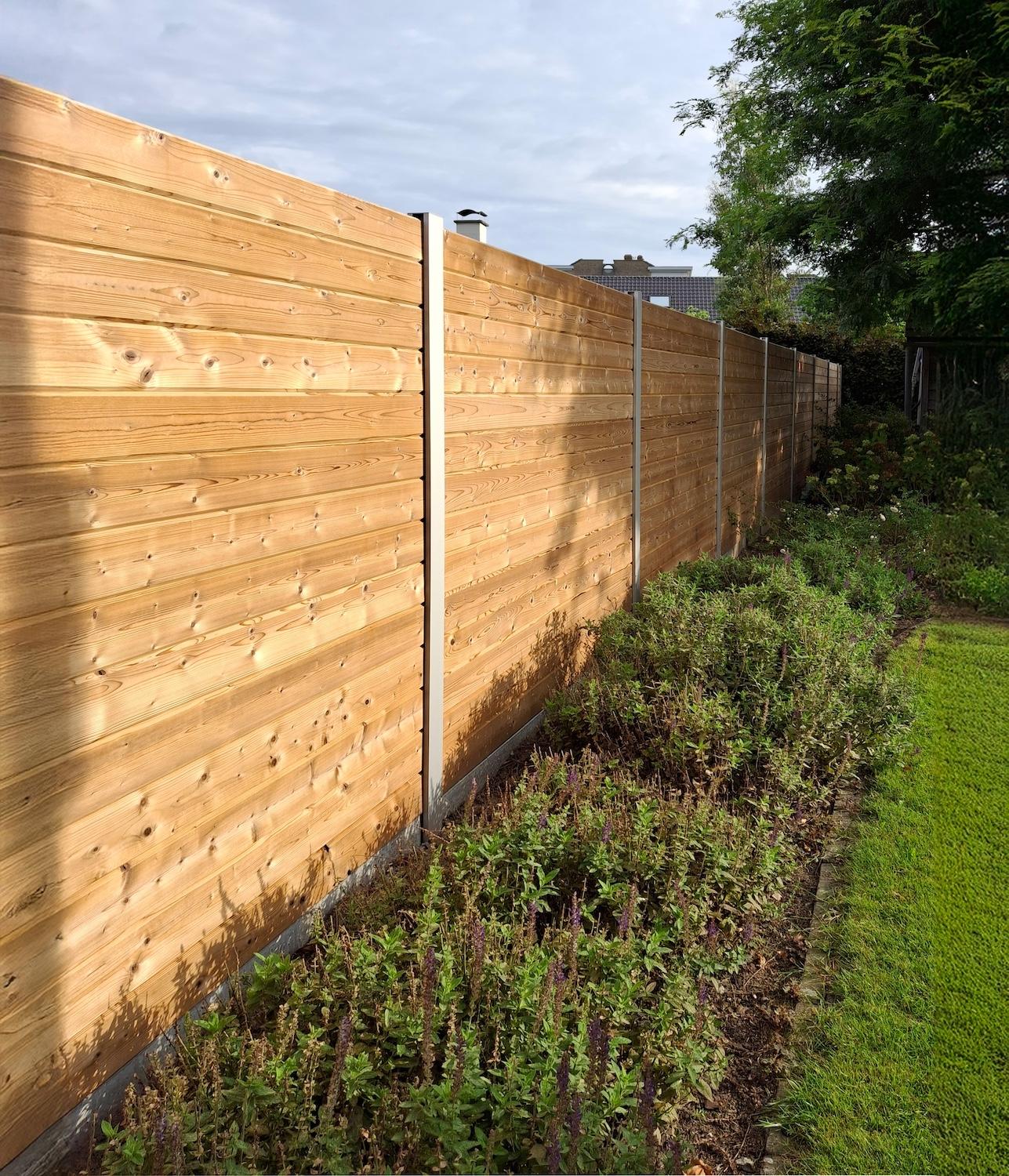 Tuinafsluiting met aluminium palen en tand en groef planken. Grenenhout.