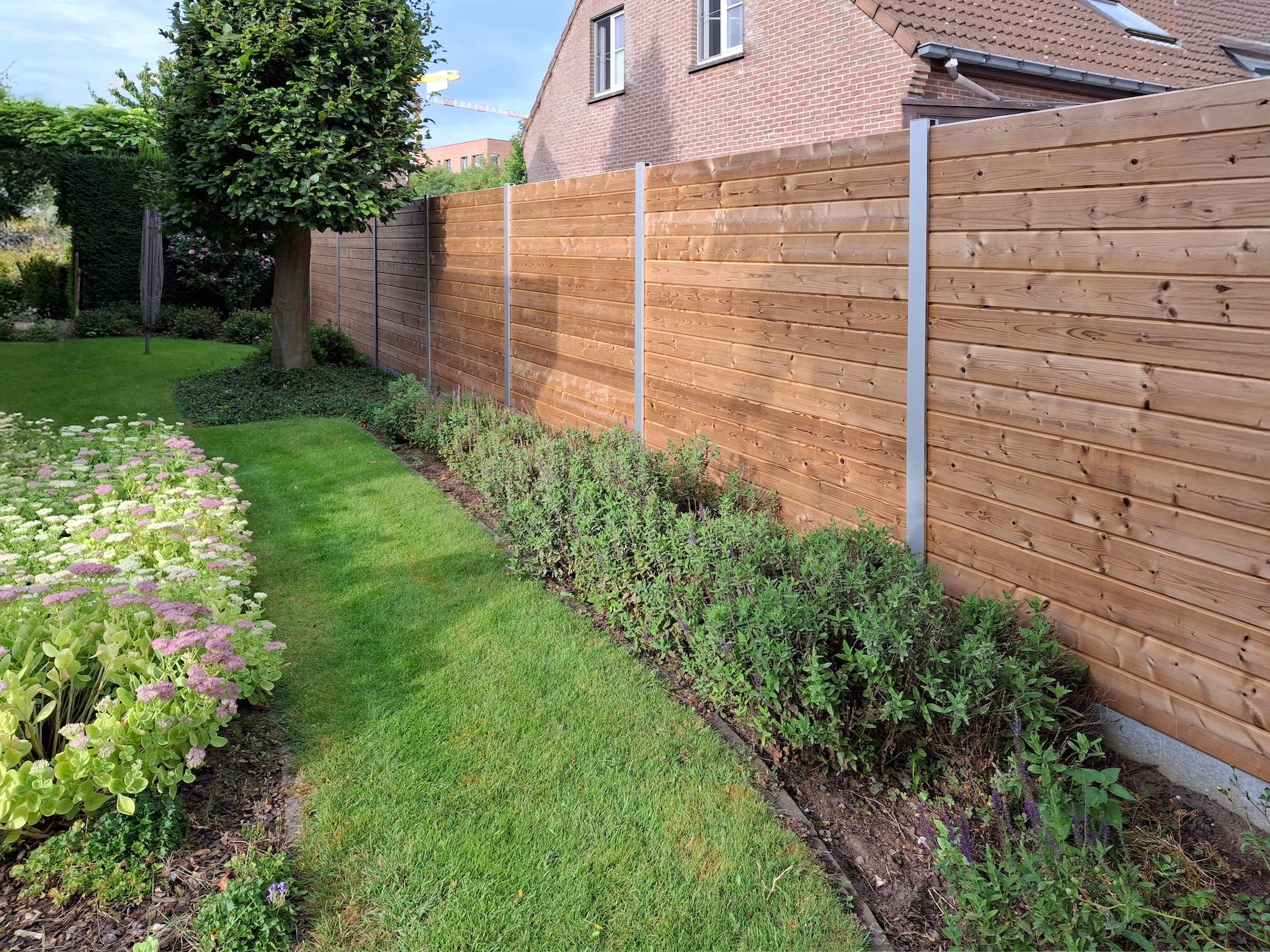 Tuinafsluiting in hout, planken tand en groef tussen aluminium palen. Grenenhout.